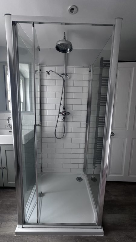 The old shower, a framed glass enclosure.