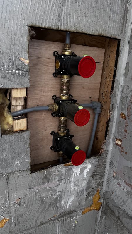 Brass shower valves set into the wall.