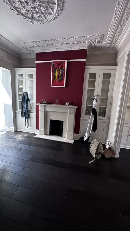 The front reception room before the work, a red chimney breast and glazed alcove cupboards