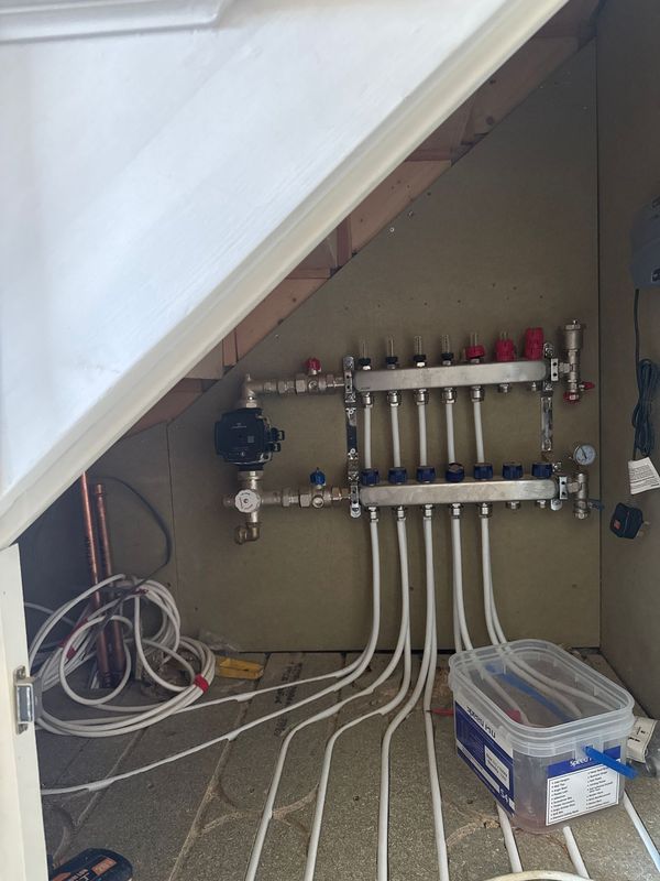 The underfloor heating manifold under the stair