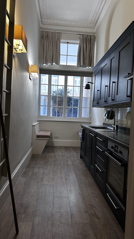 The old galley kitchen under a very tall ceiling.