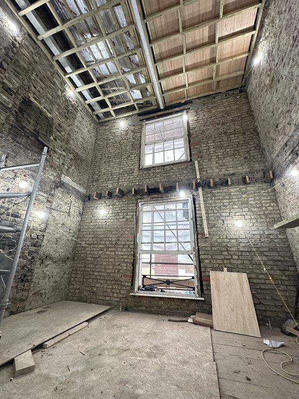 The house taken back to its brick walls, with new joists above.