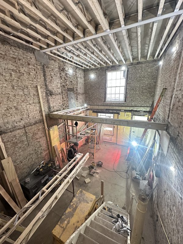 Looking down through the stripped house, new floor structure going in.