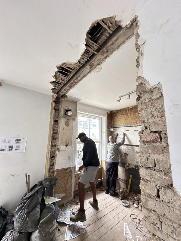 A wall being opened up between two rooms.