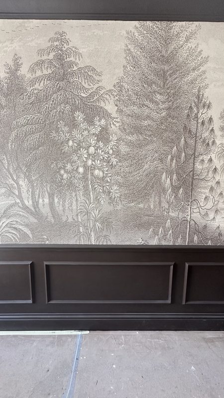 The scenic mural above dark panelling, during the fit out.