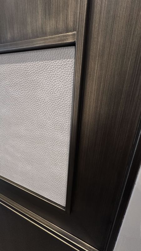 Bronzed oak frame with a textured pale leather inset panel.