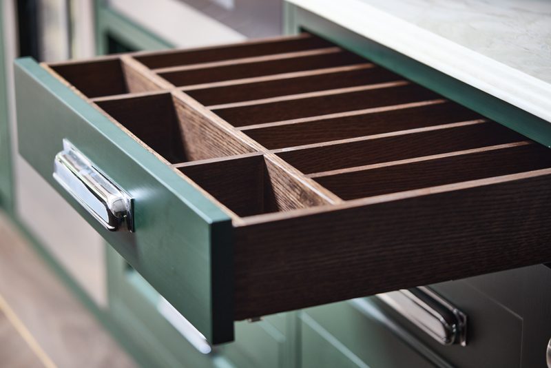 Drawer opened to show dark timber dividers and chrome handles.