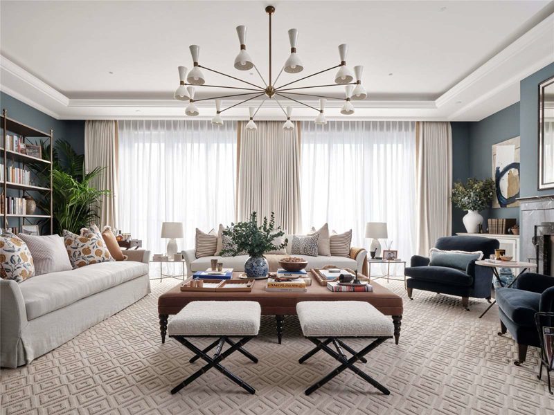 Living room in soft blue with daylight through sheer curtains.