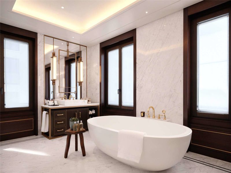 Bathroom with marble walls, dark timber and brass fittings.