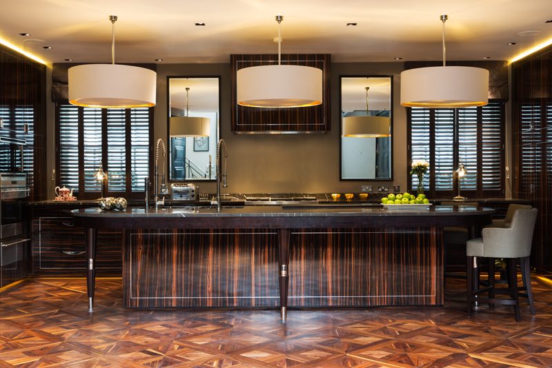 Kitchen in dark figured timber with a dark marble worktop.