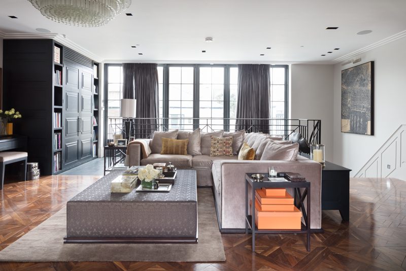 Living room with tall steel windows and herringbone parquet.