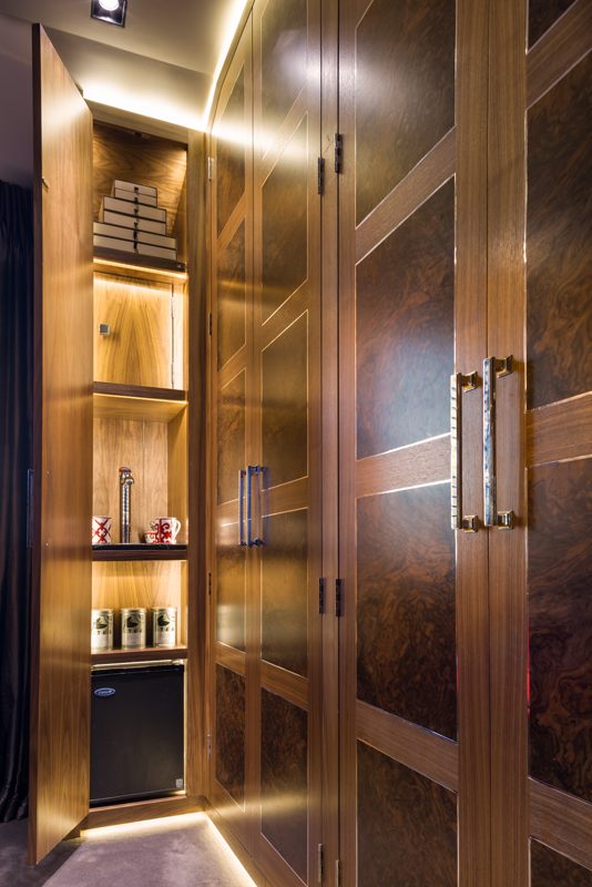 Walk in wardrobe in burr walnut with a fitted tea station.