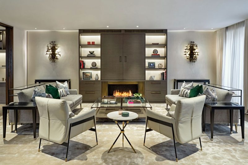 Reception room with a long fire and bronze lined shelving.