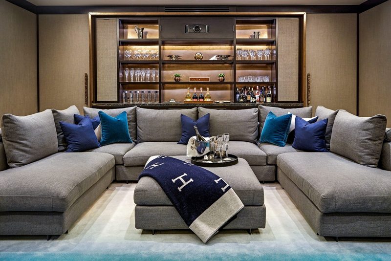 Cinema room with a deep corner sofa and copper shelving.