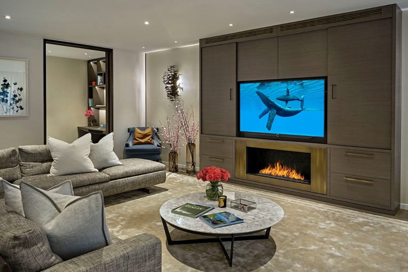 Family room with a media wall, fire and dark joinery.