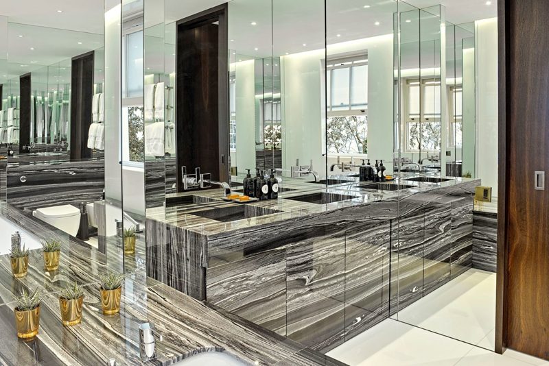 Bathroom in dramatic grey marble with mirrored walls.