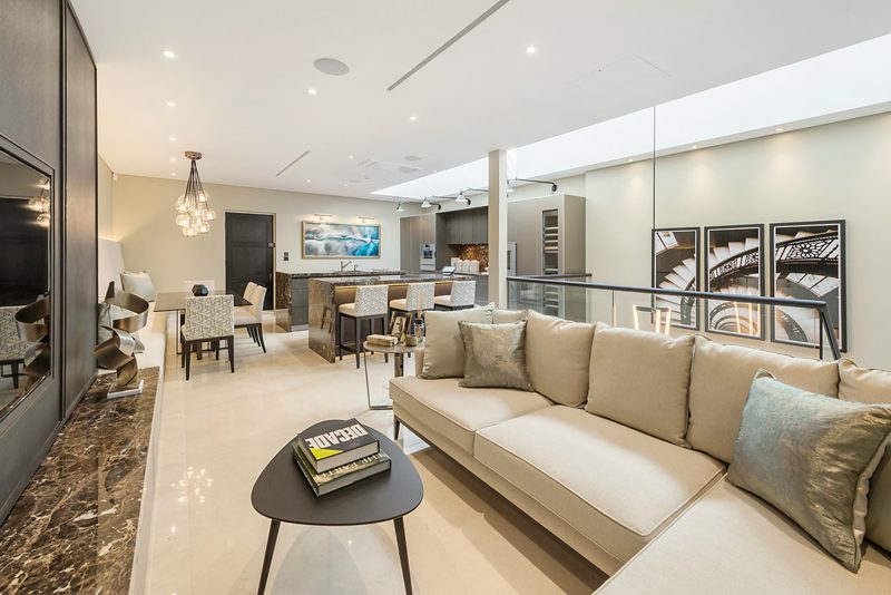 Open plan living, dining and kitchen under a long rooflight.