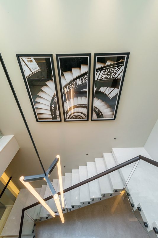 Stairwell hung with three framed photographs of spiral staircases.