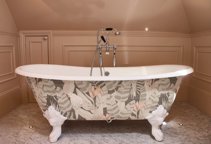 Roll top bath with a printed panel and cast claw feet.