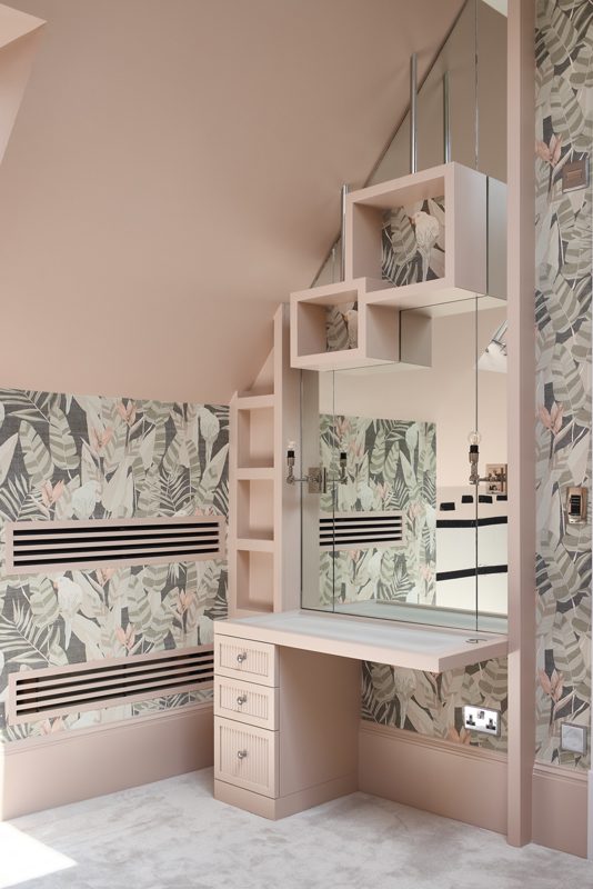Dressing table and mirrored shelves under a sloping ceiling.