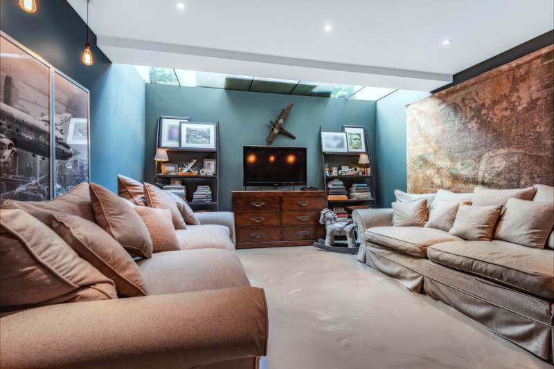 Basement snug with two deep sofas, a map mural and glass overhead.
