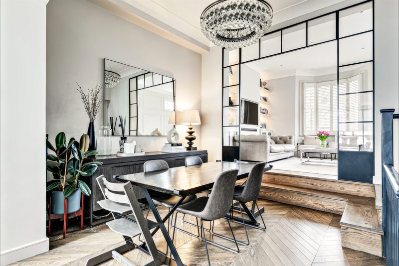 Dining table on a raised oak floor, open to the reception room.