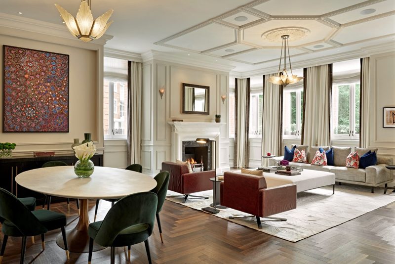 Panelled reception room with a lit fire and herringbone parquet.