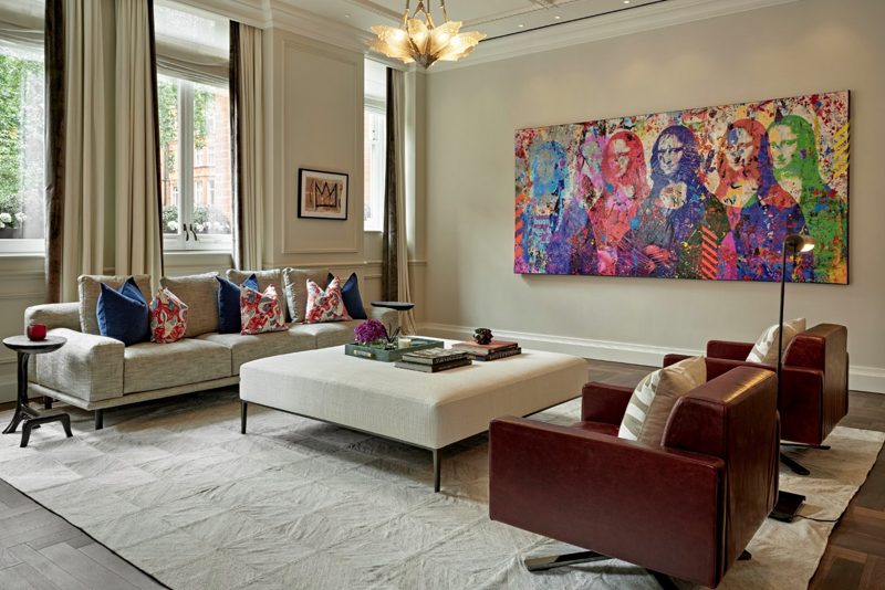 Living room with tall windows and a bold portrait painting.