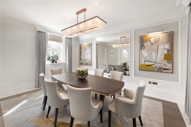 Dining room with a mirrored panel and abstract artwork.