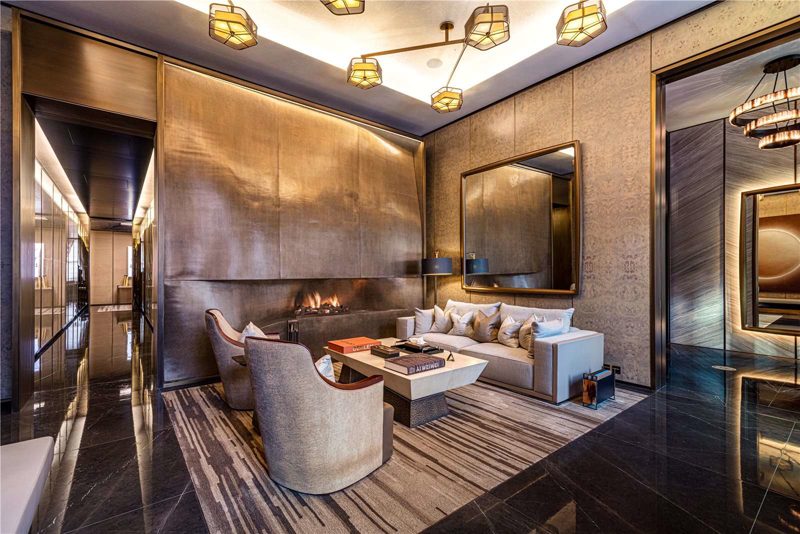 Reception room panelled in bronze with a lit fire.