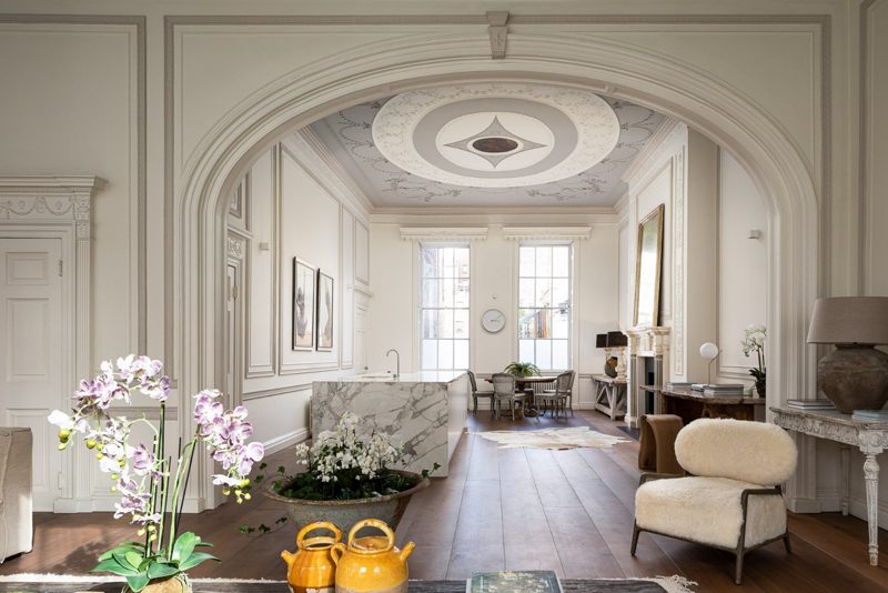 View through an arched opening into the drawing room and its tall windows.