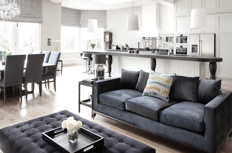 Open plan living, dining and kitchen with tall bay windows.