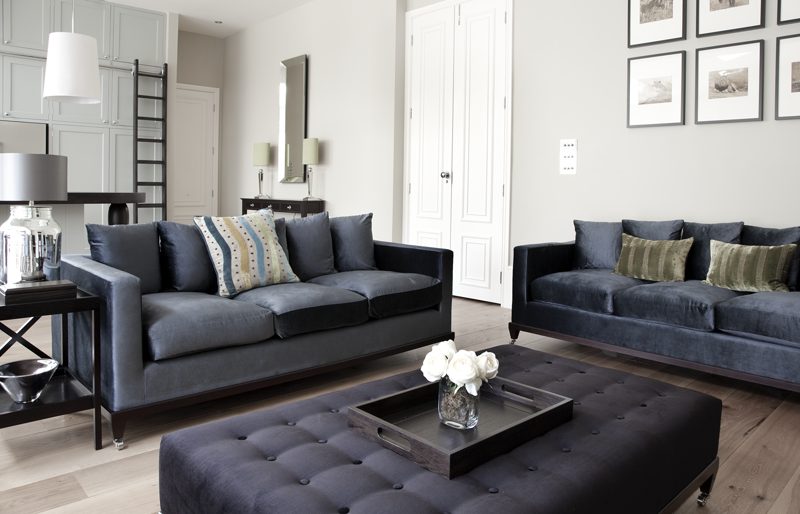 Living room with velvet sofas and framed wildlife photographs.