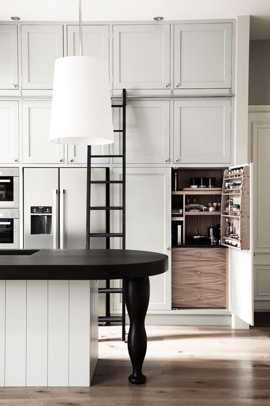 Pale kitchen with a sliding ladder and an open larder.