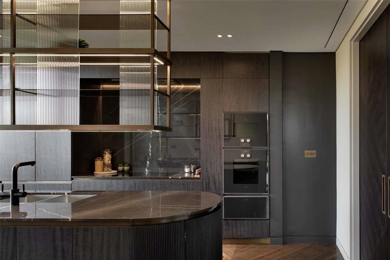 Kitchen in fumed timber with a round marble topped island.