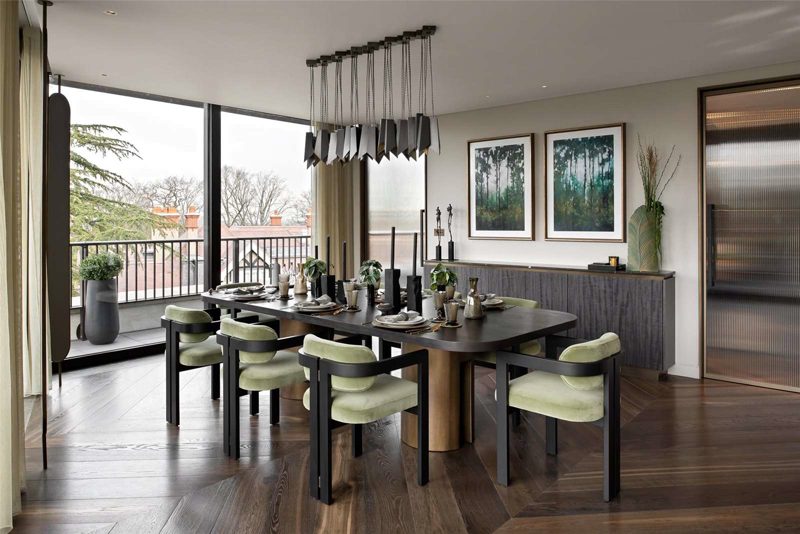 Dining table set beside glazing that opens onto the terrace.