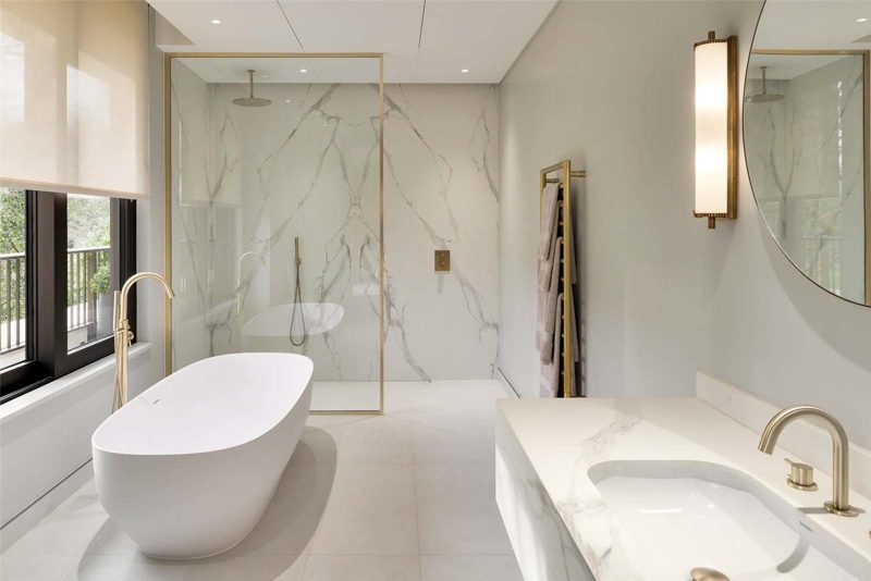 Bathroom with a freestanding bath against book matched marble.