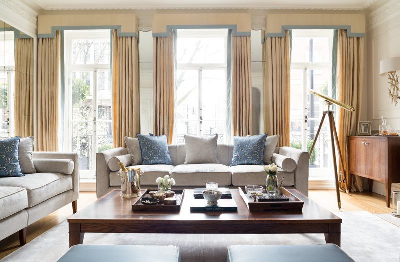 Drawing room with three tall windows and silk lined curtains.