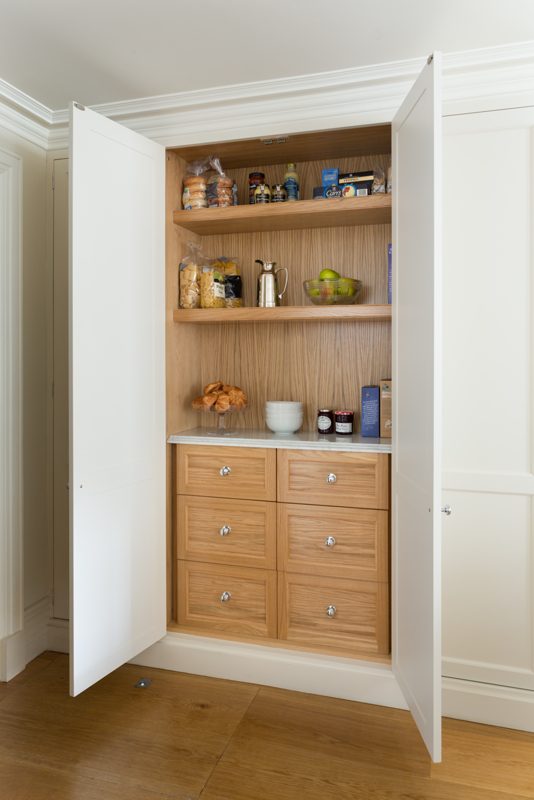 Oak larder cupboard opened to show shelves and drawers.